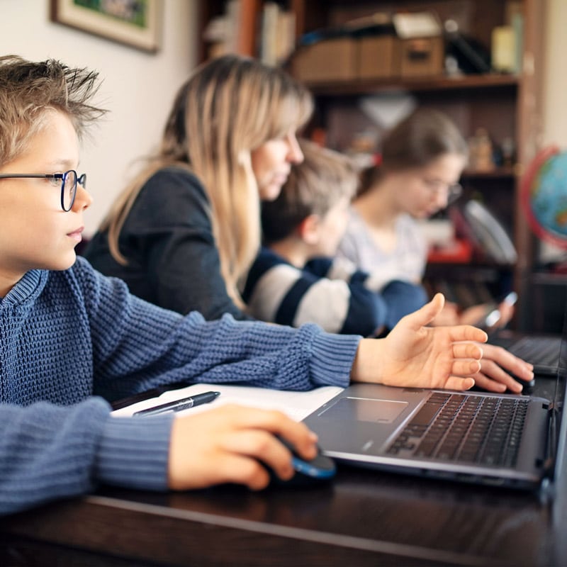 Familie nutzt digitale Geräte für Online-Lernen und Kommunikation im Homeoffice mit schneller Glasfaserverbindung.