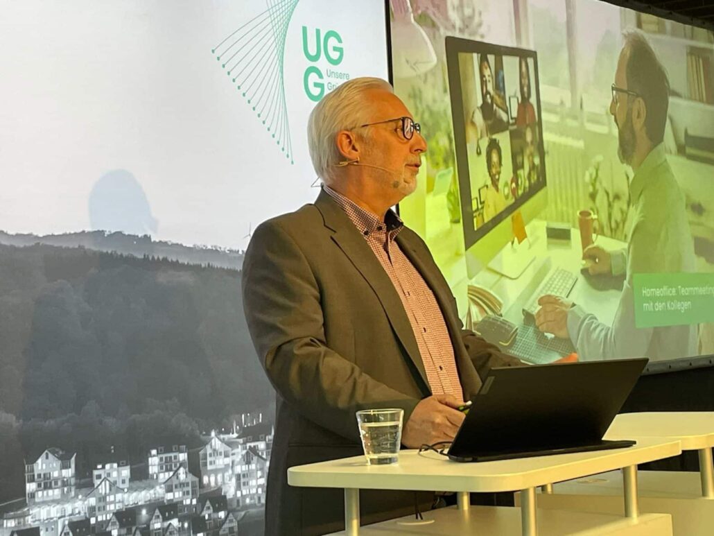 Experte von Unsere Grüne Glasfaser präsentiert digitale Lösungen für Homeoffice und Teamarbeit während einer Veranstaltung.