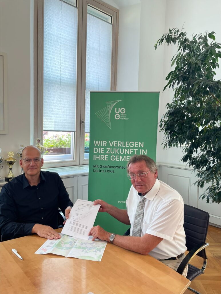 Vertragsunterzeichnung für den Glasfaserausbau: Vertreter von Unsere Grüne Glasfaser präsentieren den Plan für die Gemeinde.