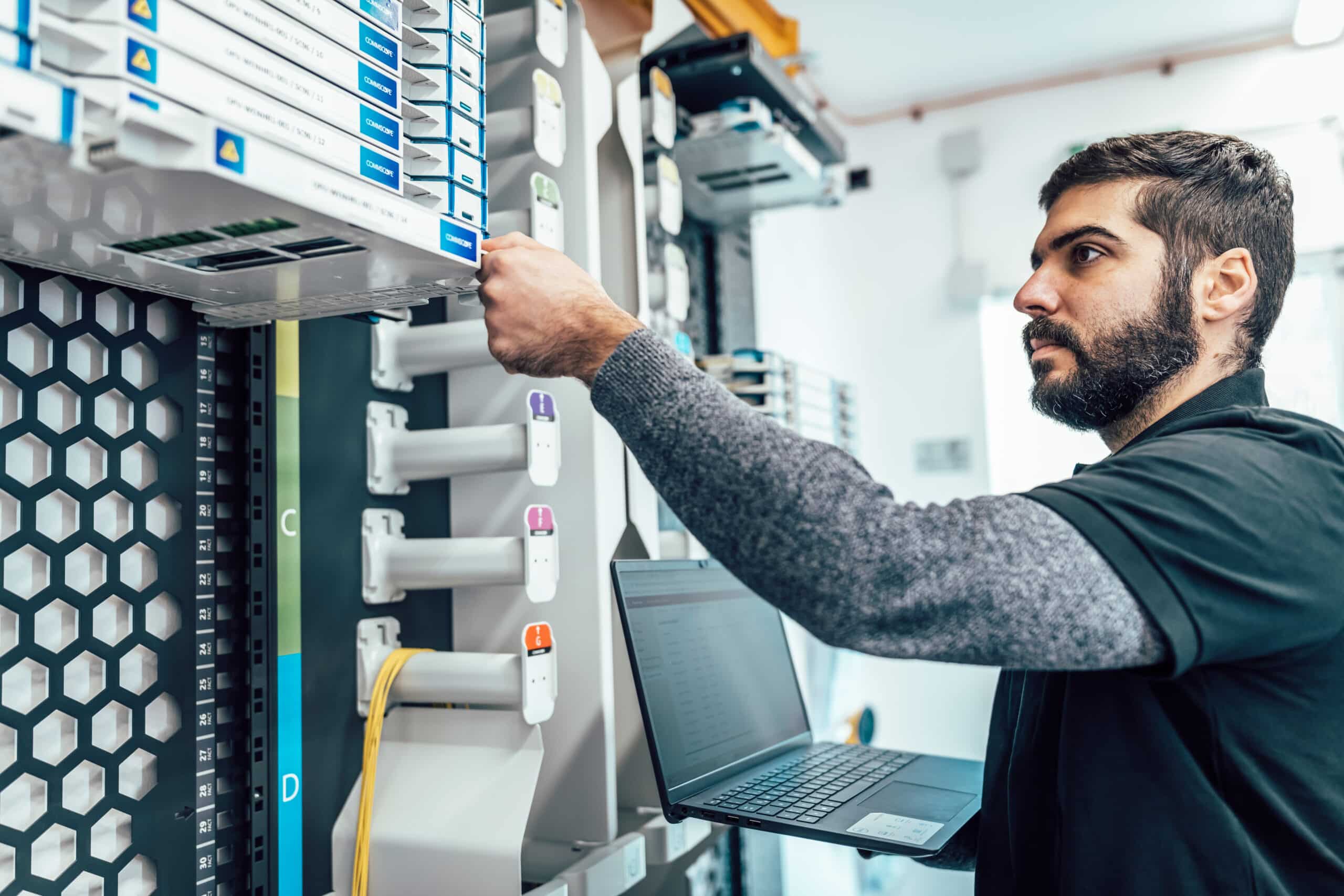 Techniker installiert Glasfaserkomponenten in einem Netzwerk, um schnelle Internetverbindungen für Kunden zu gewährleisten.