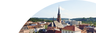 Stadtansicht mit Kirche und modernen Gebäuden, die die digitale Zukunft durch Unsere Grüne Glasfaser symbolisiert.