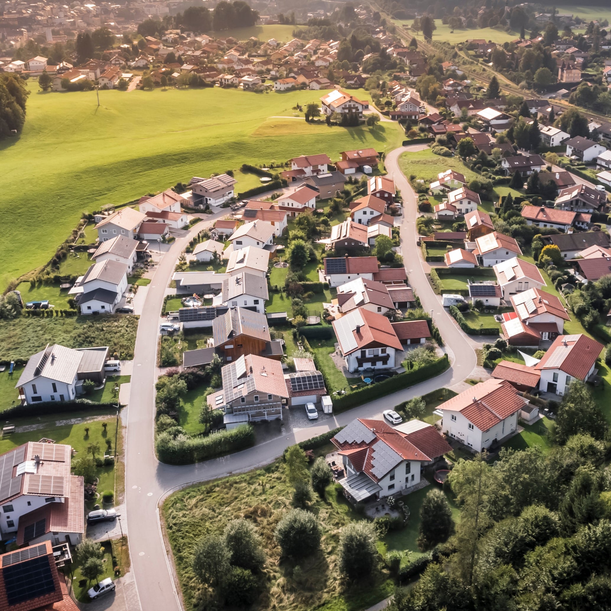 Luftaufnahme eines Wohngebiets mit Einfamilienhäusern und grünen Flächen, ideal für schnelle Glasfaseranschlüsse.