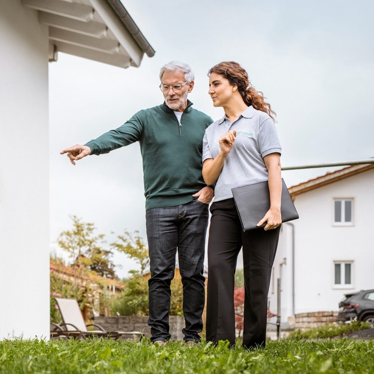 Beratungsgespräch zwischen einem Techniker und einem Kunden zur Installation von Glasfaseranschlüssen im Garten.