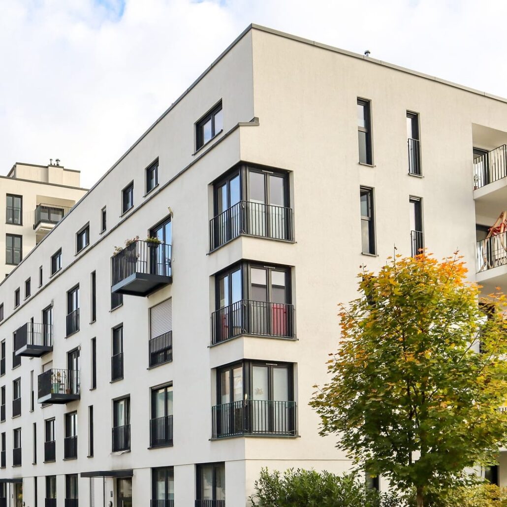 Moderne Wohnanlage mit Balkon und Fenstern, ideal für schnelle Internetanbindung durch Unsere Grüne Glasfaser.