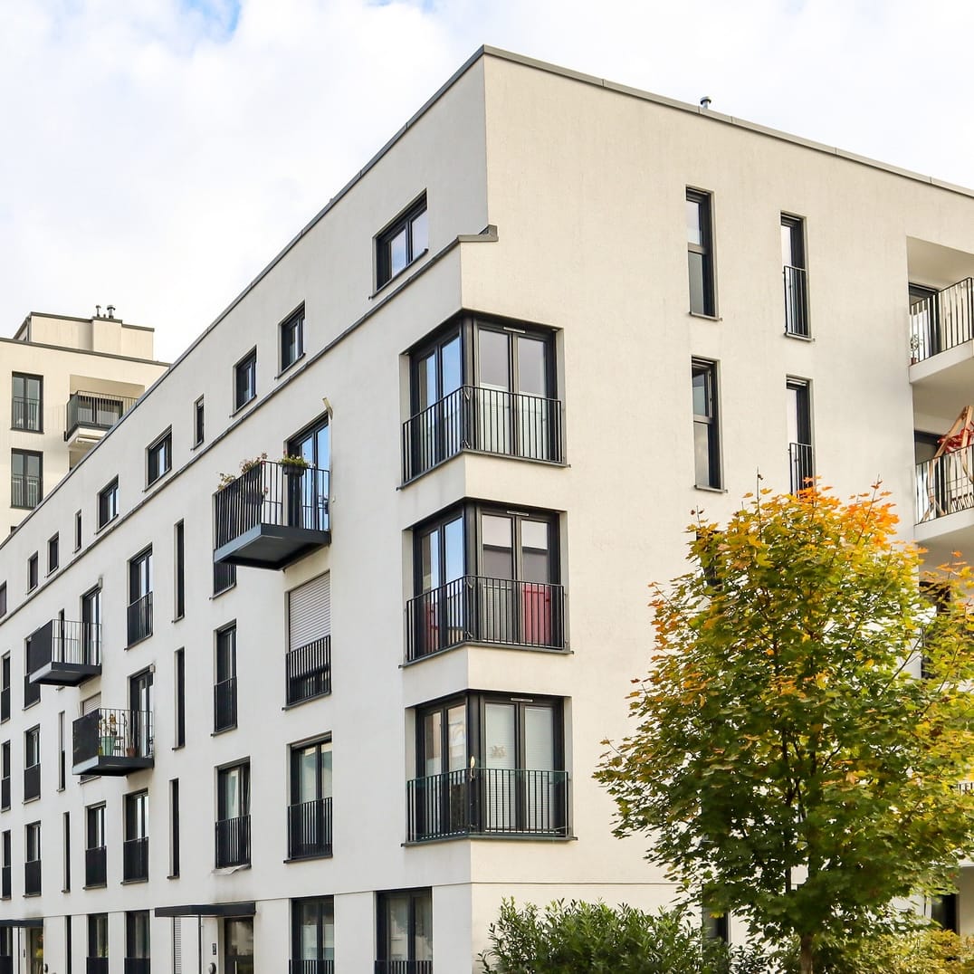 Moderne Wohnanlage mit Balkon und Fenstern, ideal für schnelle Internetanbindung durch Unsere Grüne Glasfaser.