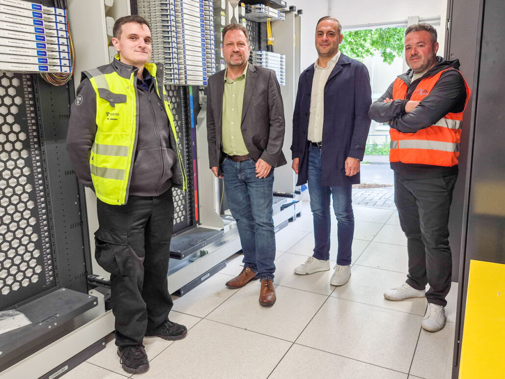 Techniker von Unsere Grüne Glasfaser bei der Verkabelung im Unternehmen, technische Infrastruktur für schnelle Internetverbindungen.